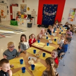 Dzieci siedzą za stołami w przedszkolu podczas posiłku