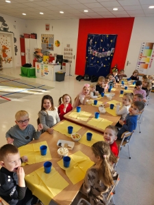 Dzieci siedzą za stołami w przedszkolu podczas posiłku