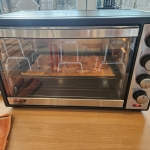 Piekarnik z pieczywem na ruszcie, stojący na drewnianym stole