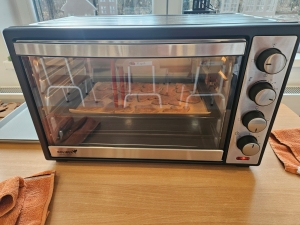 Piekarnik z pieczywem na ruszcie, stojący na drewnianym stole