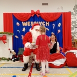 Santa Claus rozmawia z dziewczynką w czerwonej sukience