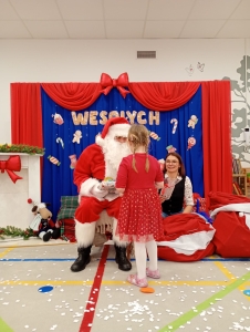 Santa Claus rozmawia z dziewczynką w czerwonej sukience