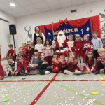 Grupa dzieci w strojach świątecznych z Mikołajem i nauczycielką