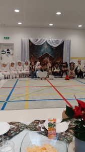 Dzieci w strojach przed sceną z żłóbkiem w tle