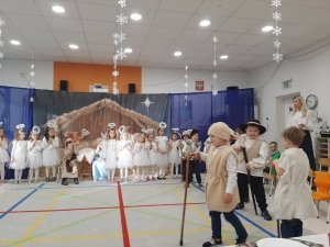 Dzieci w strojach przedstawiają scenę w żłobku w szkolnym przedstawieniu