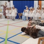 Dzieci w kostiumach aniołów i leżące na podłodze w sali