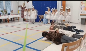 Dzieci w kostiumach aniołów i leżące na podłodze w sali