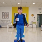 Chłopiec na desce równowagi w pomieszczeniu z żółtą ścianą